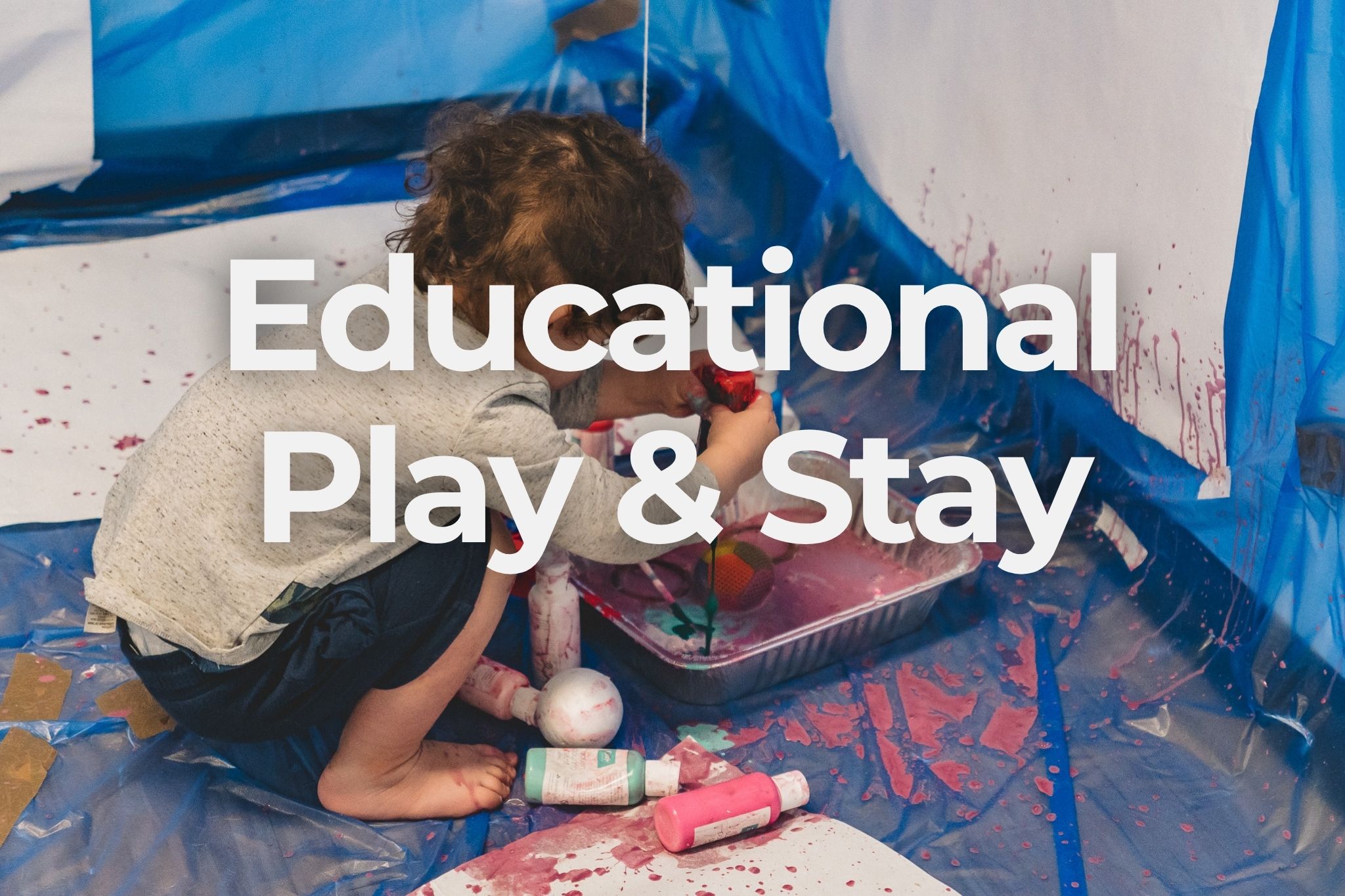 A toddler exploring messy paint play at an Educational Play & Stay session